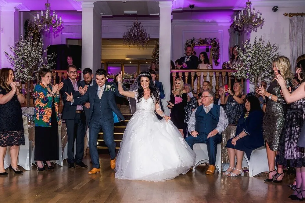 Bride and groom grand entrance with guests cheering